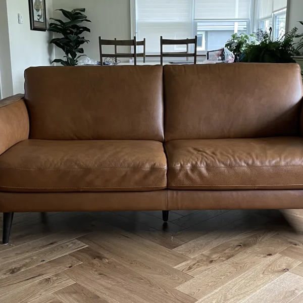 Brown leather couch on hardwood floors