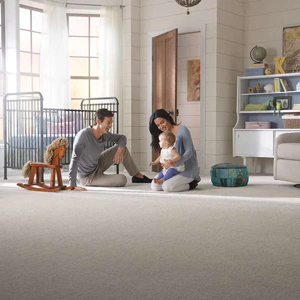 Young family playing with a child on carpet