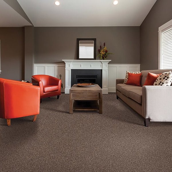 Living room with chairs and a long couch on carpet
