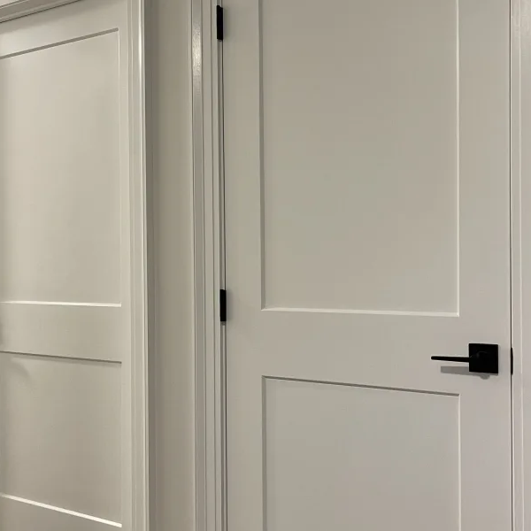 2 modern white doors in a hallway